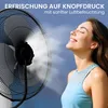 A woman is enjoying the mist from a fan on a bright day. Produktbild-Vorschau