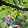 A person is using a Ryobi electric saw to cut a tree branch. Podgląd zdjęcia produktu