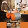 A fitness roller with handles and knee pads is shown on a wooden floor, with a smaller inset image showing someone using it. Three circular icons depicting abdominal muscles are at the bottom. Produktbild-Vorschau