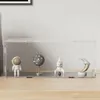 A transparent display box with space-themed figurines inside, placed on a wooden surface. Podgląd zdjęcia produktu