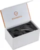 A white box with the Schuberth logo and product name on the lid, containing two black electronic communication devices nestled in black foam padding. Produktbild-Vorschau