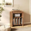 A wooden record player stand with a record player and speaker on top, and vinyl records in the shelves below, in a room setting. Produktbild-Vorschau