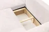 A close-up view of the internal storage compartment of a beige sofa. Voir les images du produit