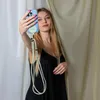 A young woman is taking a selfie with her phone, which has a lanyard attached. Anteprima dell’immagine prodotto