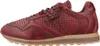 A side view of a red leather sneaker with perforated details and a tan sole. Voir les images du produit