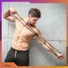 A muscular man is performing a workout using resistance bands. Podgląd zdjęcia produktu