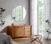 A modern living room with a wooden sideboard, a unique irregular mirror, and sheer curtains. Produktbild-Vorschau