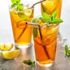 Three glasses of iced tea with mint and lemon slices, with lemon slices and mint sprigs on the side. Produktbild-Vorschau