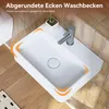 A white ceramic washbasin with a silver faucet is shown in a bathroom setting with tiled walls and wooden flooring. Náhled obrázku produktu