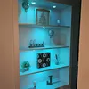 A lit-up shelf unit displaying various decorative items. Produktbild-Vorschau