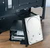 A computer case and a hard drive are shown on a wooden surface. Produktbild-Vorschau