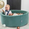 A baby is playing in a ball pit filled with colorful balls. Voir les images du produit