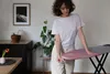 A woman is adjusting an ironing board in a room. Voir les images du produit