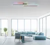 A modern living room with a sectional sofa, armchair, coffee table, and a large window overlooking a scenic view. A ceiling light fixture with LED lights is visible. Produktbild-Vorschau