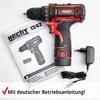 A cordless drill, its manual, and a charger are laid out on a white surface. Produktbild-Vorschau