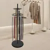 A black rotating stand displaying several belts in a retail or showroom setting. Podgląd zdjęcia produktu