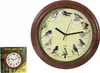 A round wall clock with a wooden frame, featuring illustrations of various birds around the dial. A smaller image of the clock in its packaging is visible to the left. Náhled obrázku produktu
