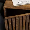 A close-up shot of a wooden nightstand with a book on top. Produktbild-Vorschau