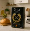 A kitchen counter with a can of olive oil, a loaf of bread, and a bowl of olives. Produktbild-Vorschau