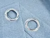 Two silver grommets are shown on a blue fabric surface. Produktbild-Vorschau