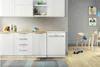 A modern kitchen with white cabinets and a white dishwasher, adjacent to a dining area with a wooden table and chairs. Voir les images du produit