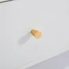 A close-up of a gold drawer knob on a white surface. Anteprima dell’immagine prodotto