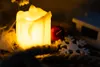 A close-up of a decorative LED candle with a snowflake and a small red ornament. Náhľad obrázku produktu