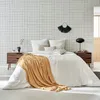 A bedroom scene with a bed, nightstands, and a grid-patterned wallpaper. Produktbild-Vorschau