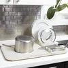 A kitchen counter with a dish drying mat, a pot, plates, and cutlery. Náhľad obrázku produktu
