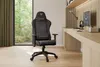 A gaming chair is positioned in a modern home office setting, next to a desk with a computer. Produktbild-Vorschau