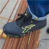 A person wearing blue jeans and black and yellow U-Power safety shoes is standing on a pile of rusty metal rods. Produktbild-Vorschau