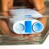 Hands holding a water filter under water in a glass container. Produktbild-Vorschau