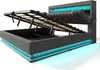 A modern upholstered bed frame with its storage compartment open, revealing the lift mechanism and storage space. The bed has integrated LED lighting along its base and headboard. Náhled obrázku produktu