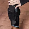 A person's hand is placing a black device into a black leg brace on a horse's leg. Podgląd zdjęcia produktu