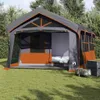 A large family tent set up on a grassy lawn with trees in the background. Produktbild-Vorschau