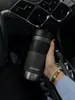 A hand holding a Contigo travel mug inside a car. Podgląd zdjęcia produktu