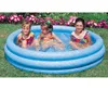 Three young girls playing in a blue inflatable pool in a grassy yard with flowers in the background. Náhled obrázku produktu