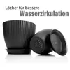 Two black plant pots with saucers are shown, with one pot upside down to reveal drainage holes. Text overlays highlight a product feature. Produktbild-Vorschau