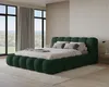 A bedroom scene with a large green bed as the focal point, positioned in front of large windows with a view of trees and hills. Voir les images du produit