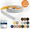 A roll of grey flexible PVC skirting board with yellow adhesive backing, shown partially unrolled, alongside a display of various color swatches. Podgląd zdjęcia produktu
