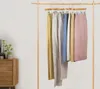 Clothes hanging on a wooden rack against a white background. Produktbild-Vorschau