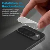 A hand is shown applying a clear protective glass cover to the camera lenses of a smartphone. Produktbild-Vorschau