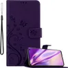 A purple flip phone case with a floral and butterfly design, shown with a smartphone inside. Produktbild-Vorschau
