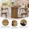 A round dining table with four chairs in a bright room with large windows. Produktbild-Vorschau
