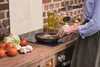 A person is cooking in a kitchen, with various ingredients on the counter. Náhľad obrázku produktu