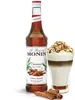 A bottle of Monin Cinnamon syrup next to a layered coffee drink with whipped cream and toppings. Podgląd zdjęcia produktu