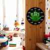 A clock with a cannabis leaf design is displayed on a wooden wall, with a blurred background of a child's room. Produktbild-Vorschau