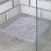 A transparent shower mat is placed on a grey tiled floor in a shower stall, with white subway tiles on the wall. Náhľad obrázku produktu
