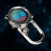 A digital watch with a carabiner clip and a compass, displayed against a dark, bokeh background. Produktbild-Vorschau