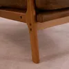 Close-up of the wooden leg and brown fabric cushion of a chair. Náhľad obrázku produktu